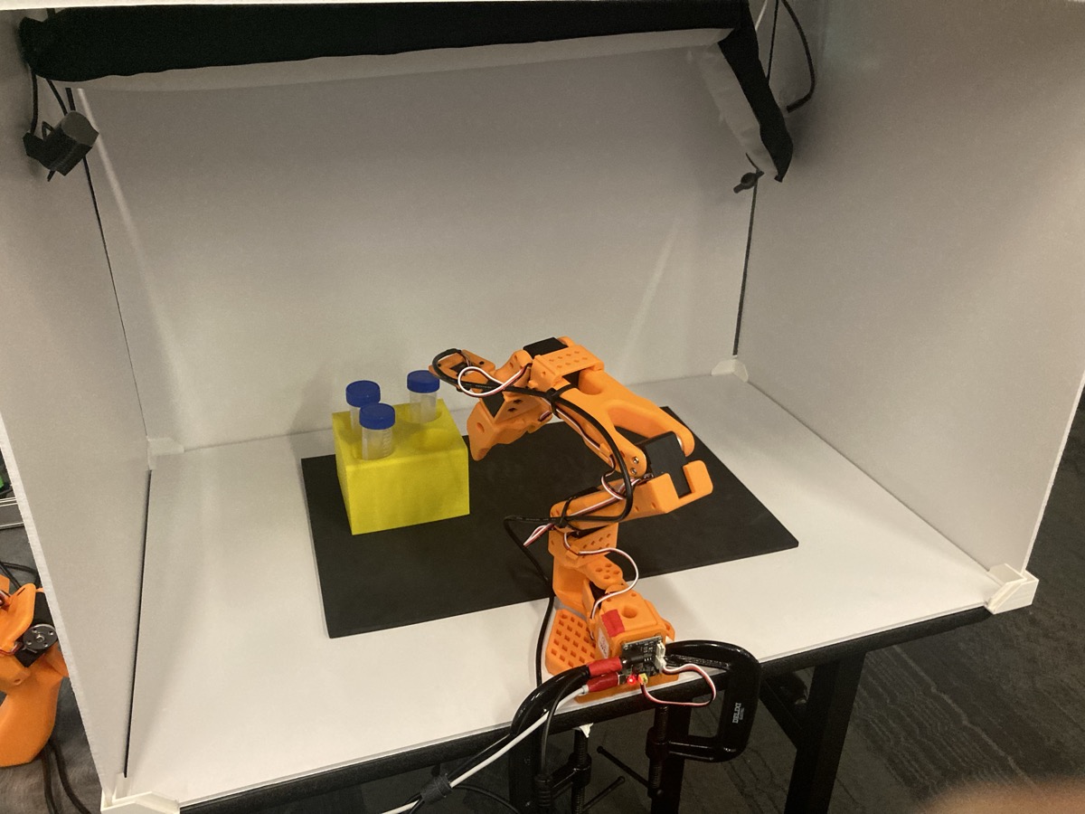 The SO-101 reaching for vials during real-world evaluation